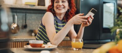red haired girl smiling holding a phone
