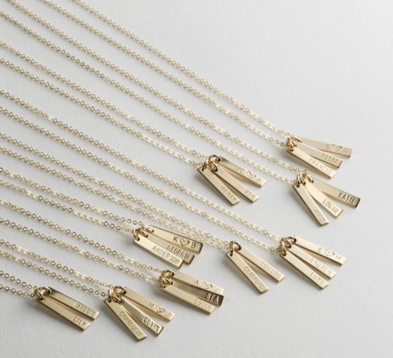 personalized gold necklaces against a white background