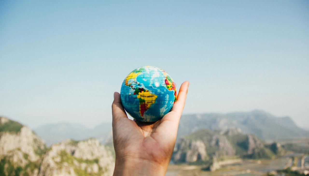hand holding up a small globe